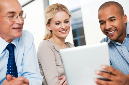 Three businesspeople working on a touchpad.